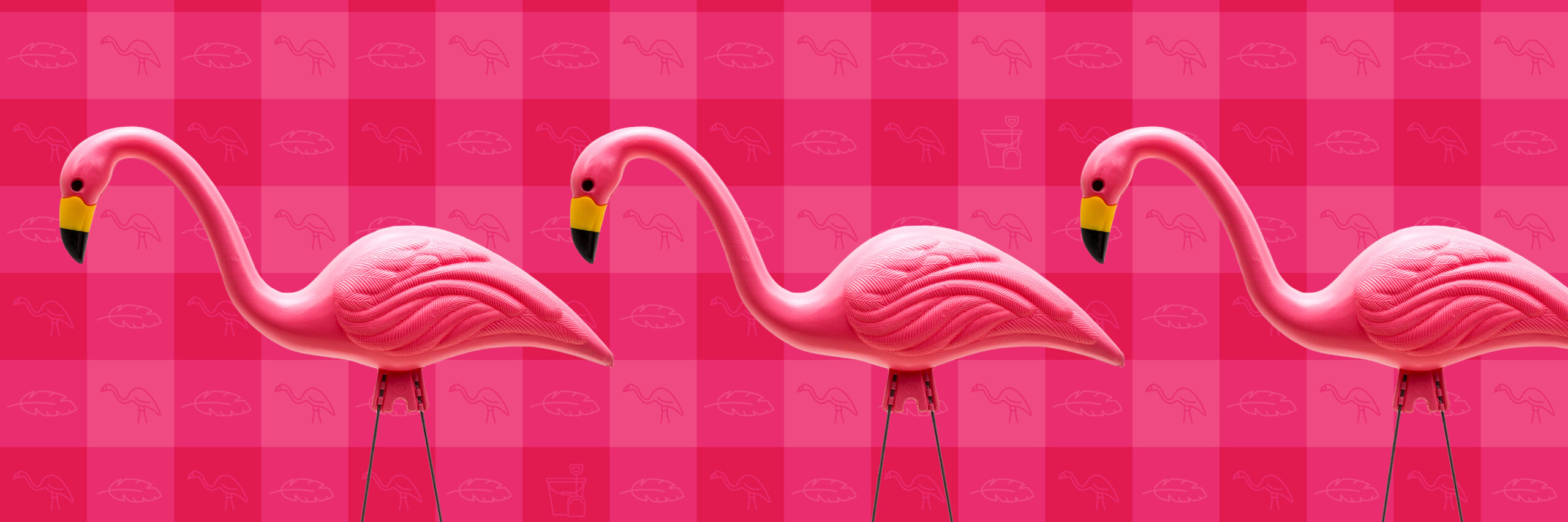 Three plastic lawn flamingos in the foreground with a gingham pink and light pink background.