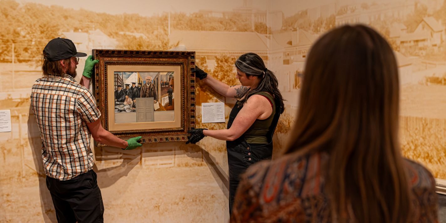 Students shown placing a piece in an exhibit