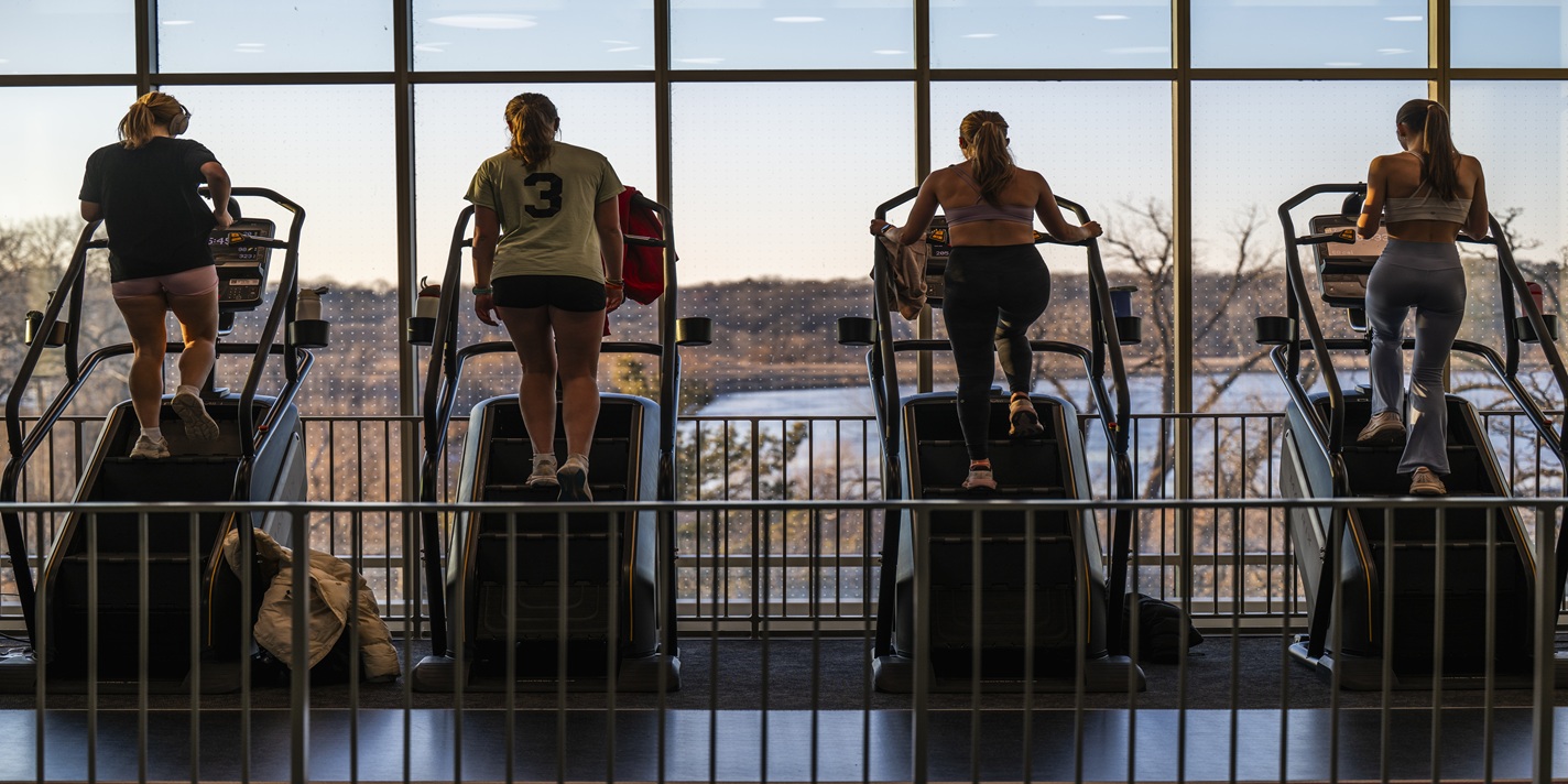 Students exercise on stair climbers in the Bakke Recreation & Wellbeing Center during sunset through at the University of Wisconsin–Madison on Feb. 25, 2026. The multilevel gym includes weight lifting, treadmills, and stair climbers.